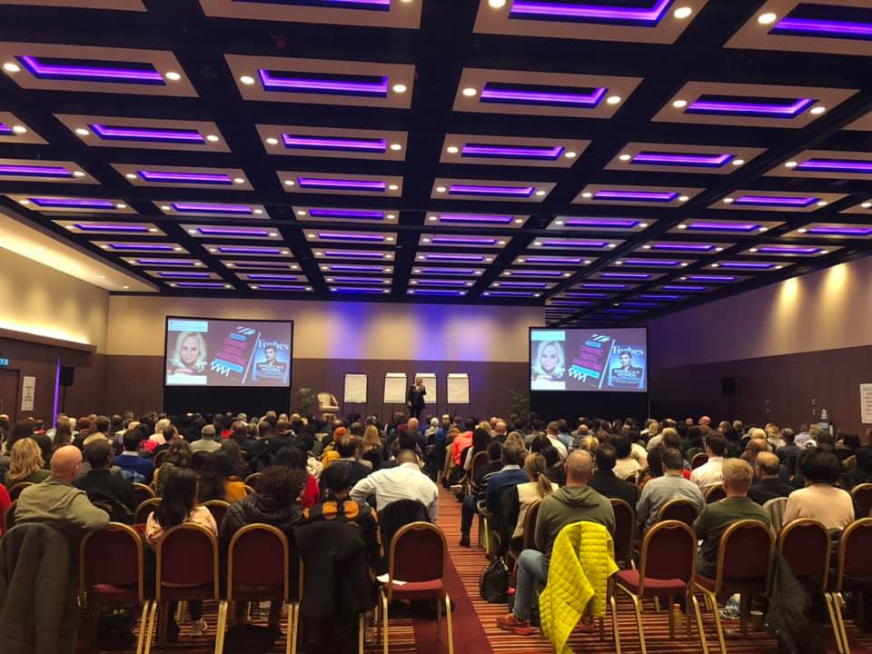 Dawn McGruer keynoting to a packed conference auditorium with her Forbes feature on screen