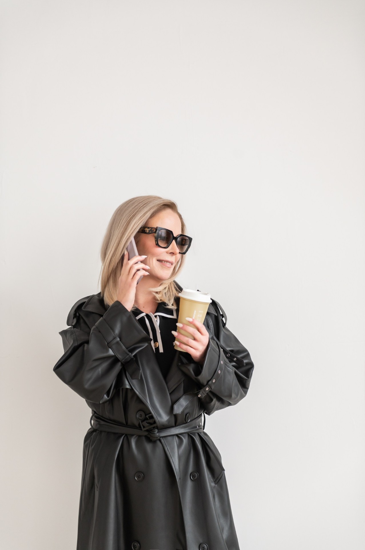 Dawn McGruer in a black trench coat with coffee